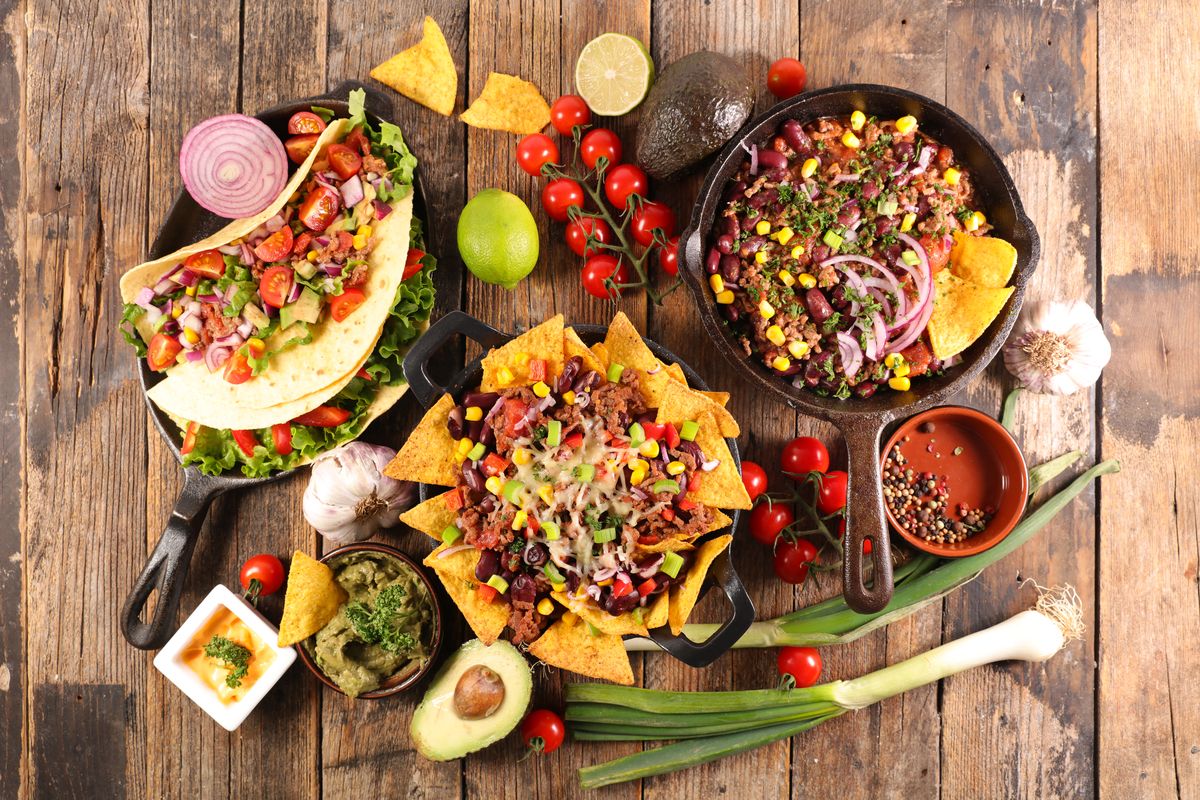 Mexican food arrangement with tacos and fresh ingredients